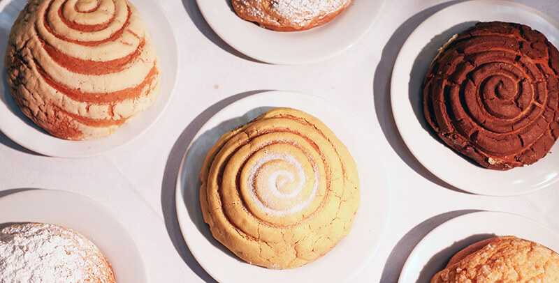 Variedad de pan dulce, incluyendo conchas de vainilla y chocolate, listo para llevar en el Caf&eacute; de Tacuba.